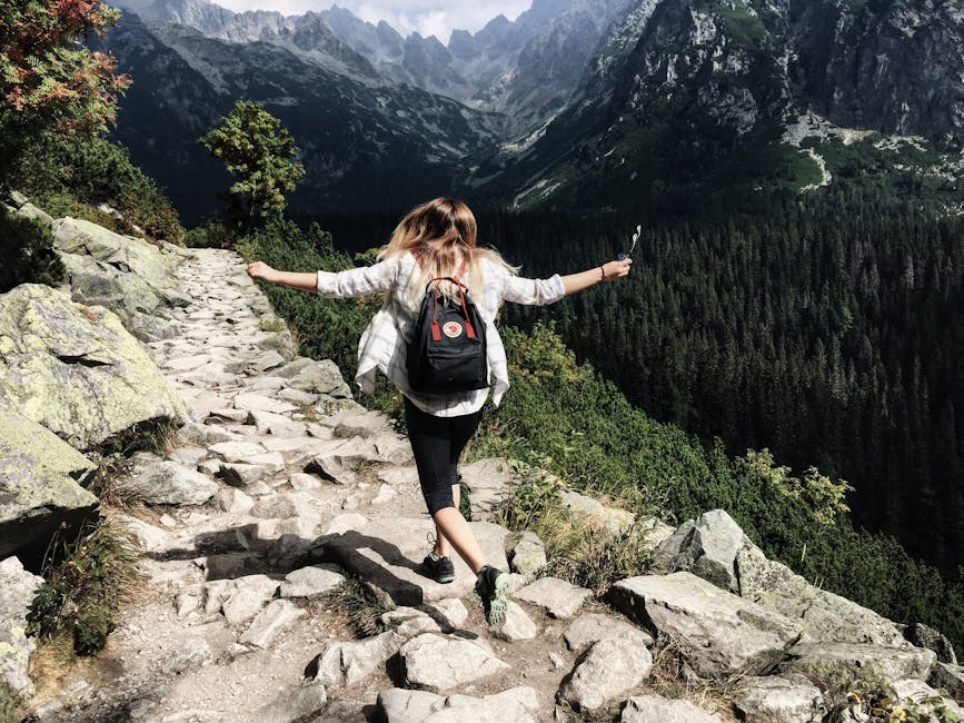 Woman hikes along rocky path in Vysoké Tatry, Slovakia. Embracing nature and freedom